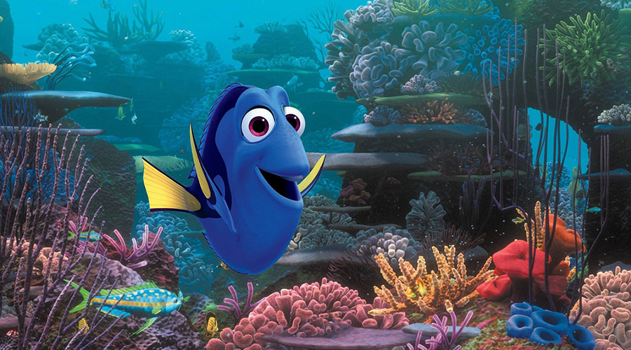 Imagem da Dory, personagem do filme Procurando Nemo e Procurando Dory. Desenho de um peixe azul com nadadeiras amarelas sorrindo no fundo do mar.