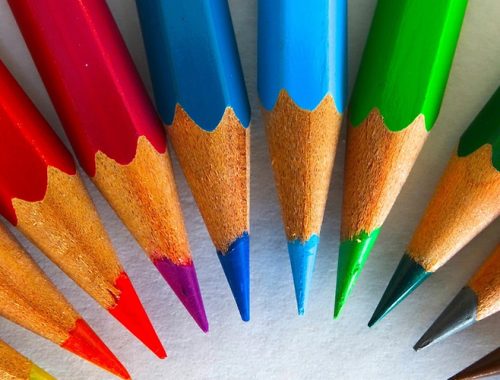 Diversos lápis de cor formando um arco-íris.