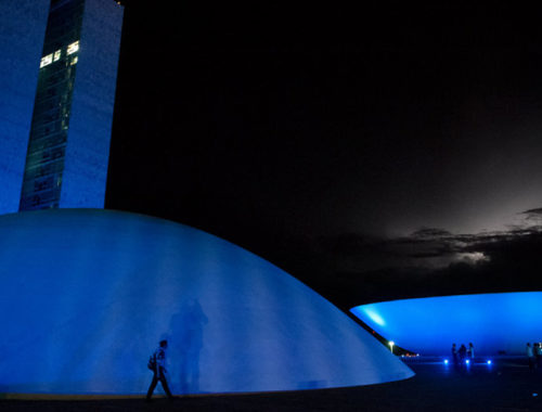 Congresso nacional em Brasília iluminado de azul.