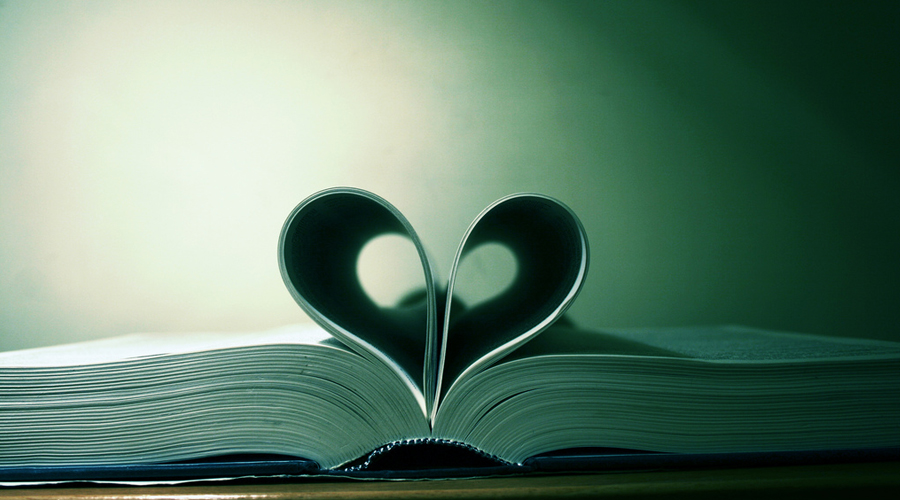 Livro aberto sob a mesa com as páginas dobradas formando um coração.